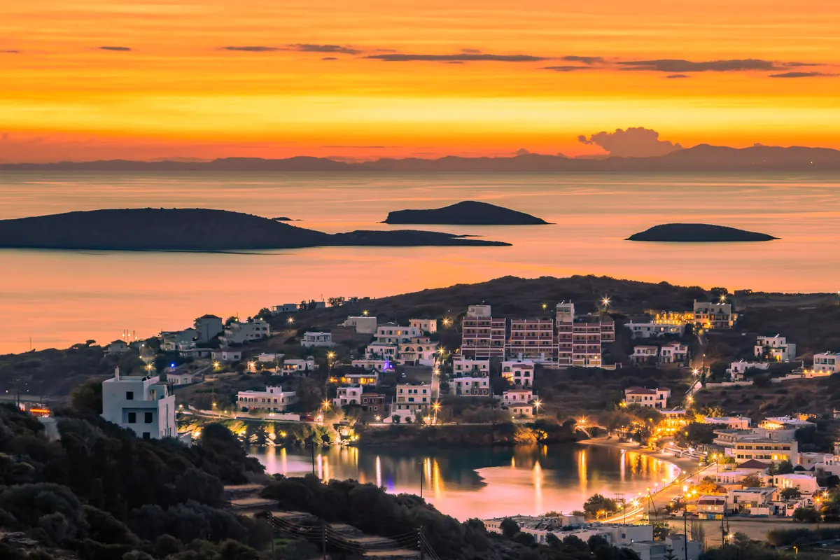 Ηλιοβασίλεμα πάνω από το Μπατσί, με τα φώτα του όρμου και νησίδες στο βάθος, Άνδρος