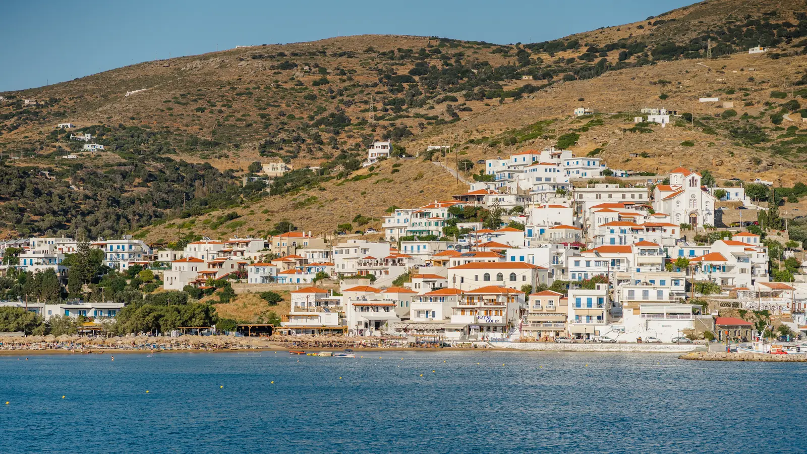 Το χωριό του Μπατσίου και η παραλία του από απέναντι, Άνδρος. Το Bella Vista Design Studios είναι στο μέτωπο της παραλίας, στο κέντρο της εικόνας.